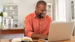 Image of a man smiling to his PC and working remotely from home